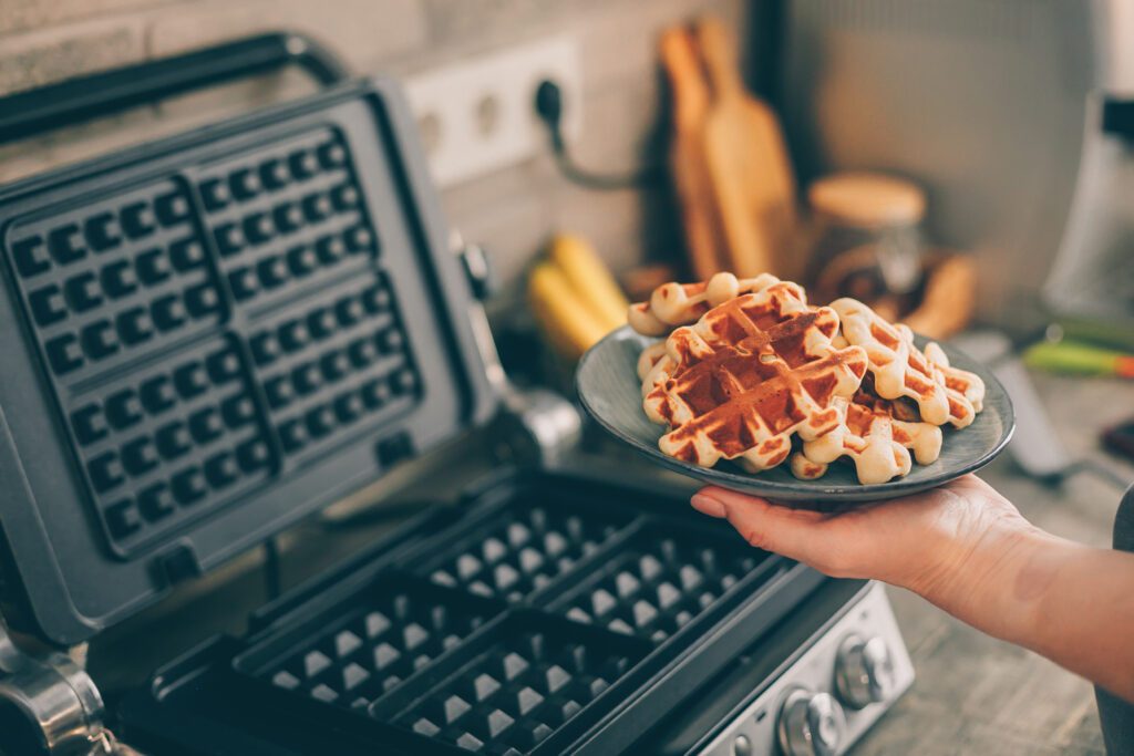 Young woman holding in hands plate with Belgian waffles