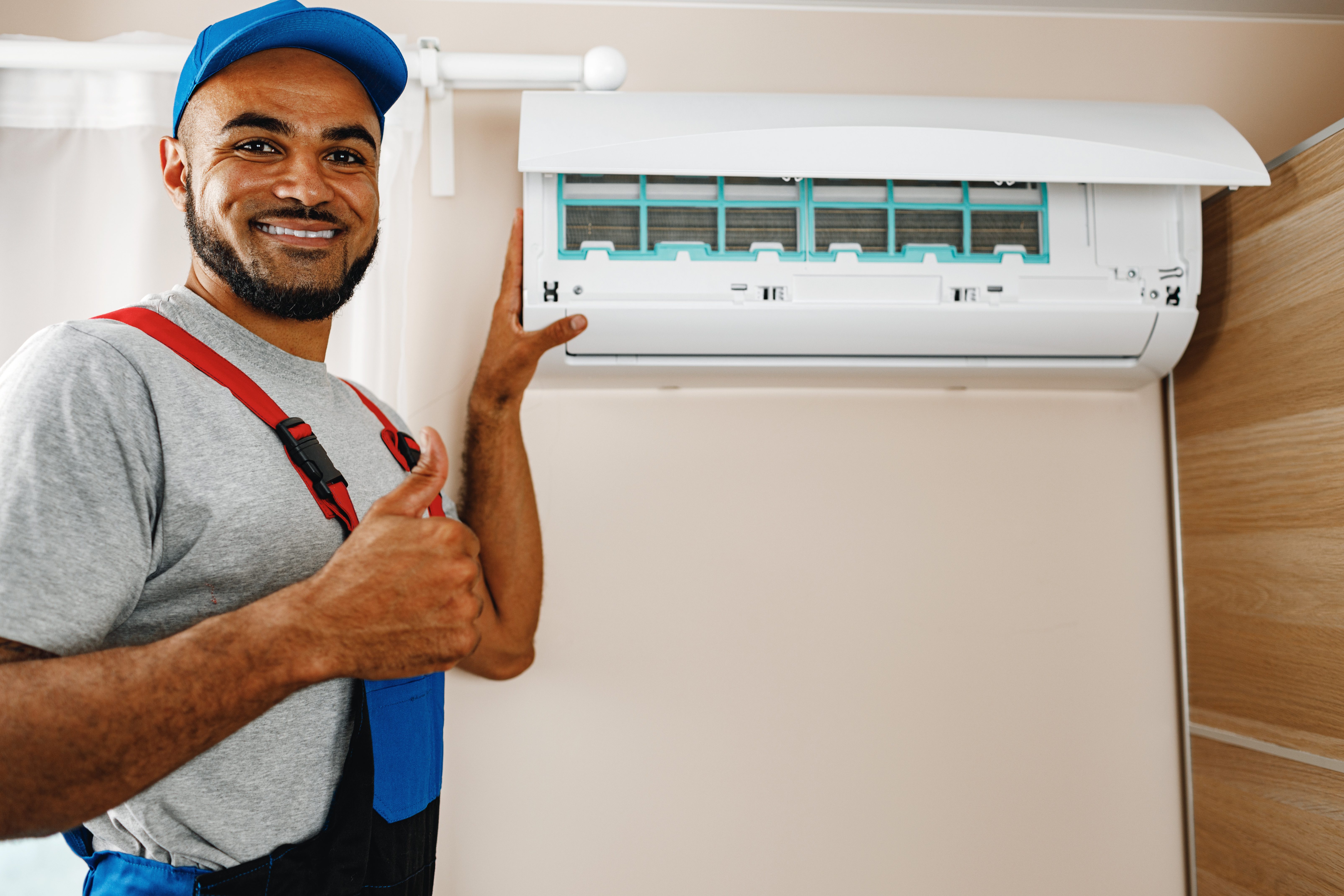 Professional repairman installing air conditioner in a room